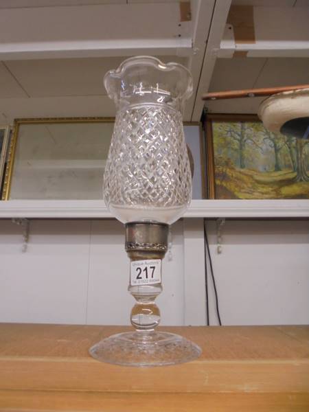 A cut glass candle lamp.