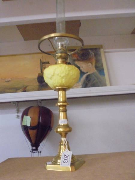 A 19th century brass drop in font candlestick oil lamp with yellow glass font and chimney.