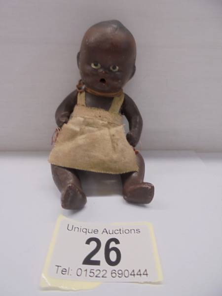 A small black baby doll, 11 cm.