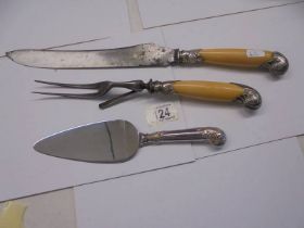 A silver handled cake slice and a carving set with silver mounts (knife a/f).