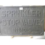 A cast iron sign - Sprinkler Stop Valve Inside.