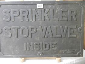 A cast iron sign - Sprinkler Stop Valve Inside.