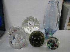 A collection of glass paperweights and a heavy glass vase.