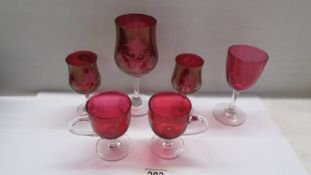 Six items of cranberry glass.