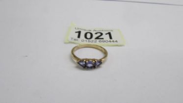 A yellow gold three stone tanzanite and diamond ring, size P half, 2 grams.