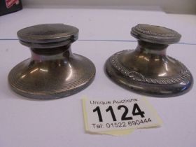 Two silver inkwells.