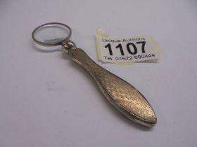 A silver handled magnifying glass.