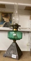 A Victorian oil lamp with green glass shade