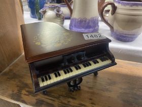 A musical box in the shape of a piano which plays O Solo Mio