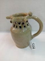 A stoneware 5 spout puzzle jug. Height 17.5cm