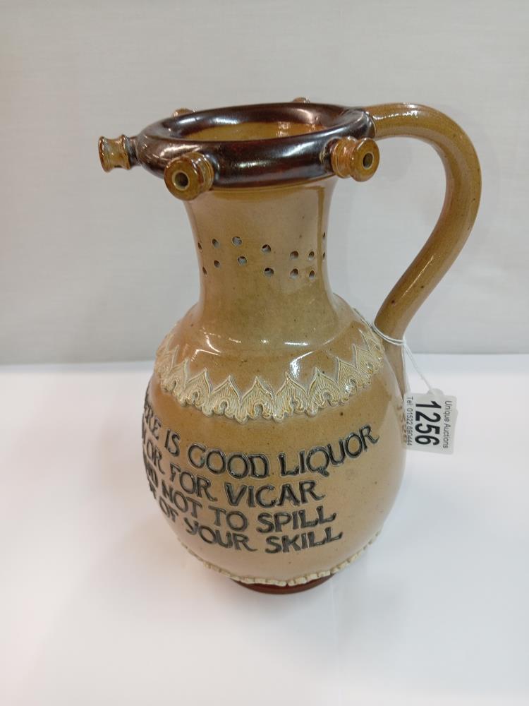 A Doulton Lambeth stoneware puzzle jug. Height 23cm