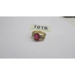 An 18ct white/yellow gold oval ruby and diamond ring, size O half, 6.2 grams.