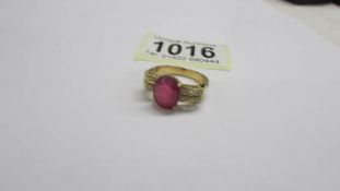 An 18ct white/yellow gold oval ruby and diamond ring, size O half, 6.2 grams.