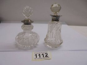 Two glass scent bottles with silver collars.