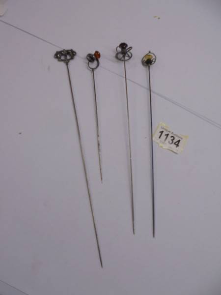 Four early 20th century silver hat pins.