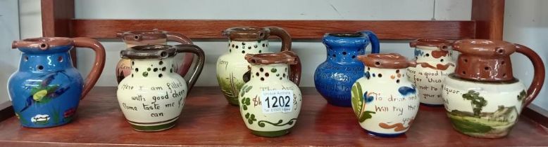 9 Torquay pottery puzzle jugs