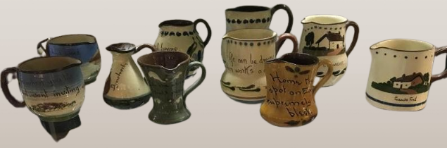 A collection of 10 Torquay ware & Motto ware jugs