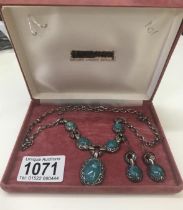An engraved silver necklace with matching earrings set with Turquoise coloured stones