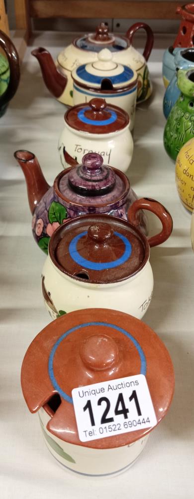 A quantity of Torquay ware preserve pots & tea pots. 7 Pieces.