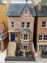 A Victorian style 4 storey dolls house with contents