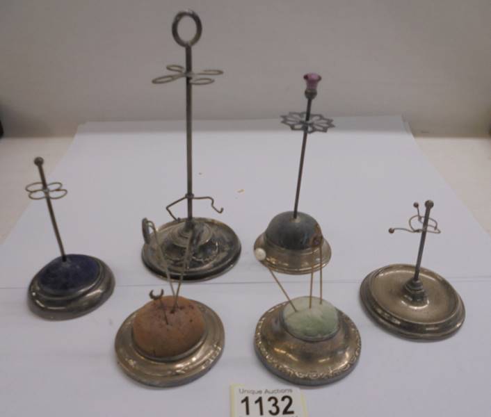 Four silver hat pin stands and two others.