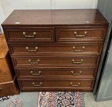 A Dark oak stained chest of drawers with brass handles