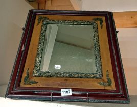 A Bevel edged mirror in a wood and metal frame.