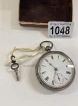 A heavy silver pocket watch with key