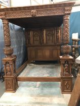 A large heavily carved mahogany bed in the design of The Great Bed of Ware