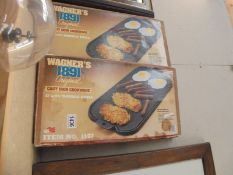 Two boxed cast iron double grills.