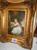 A gilt framed enhanced print of a child with a rabbit.
