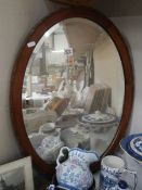 An oak framed mid 20th century oval bevel edged mirror, COLLECT ONLY.