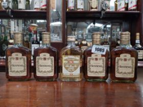 Four vintage naggins of Hennessy Brand and one John Powers.