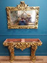 Highly carved Gilt console table with marble top and matching mirror in the Rococo style. {87 cm H x