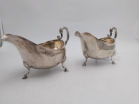 Pair of George III Irish silver sauce boats, plain oval form, leaf capped scroll handles, on three