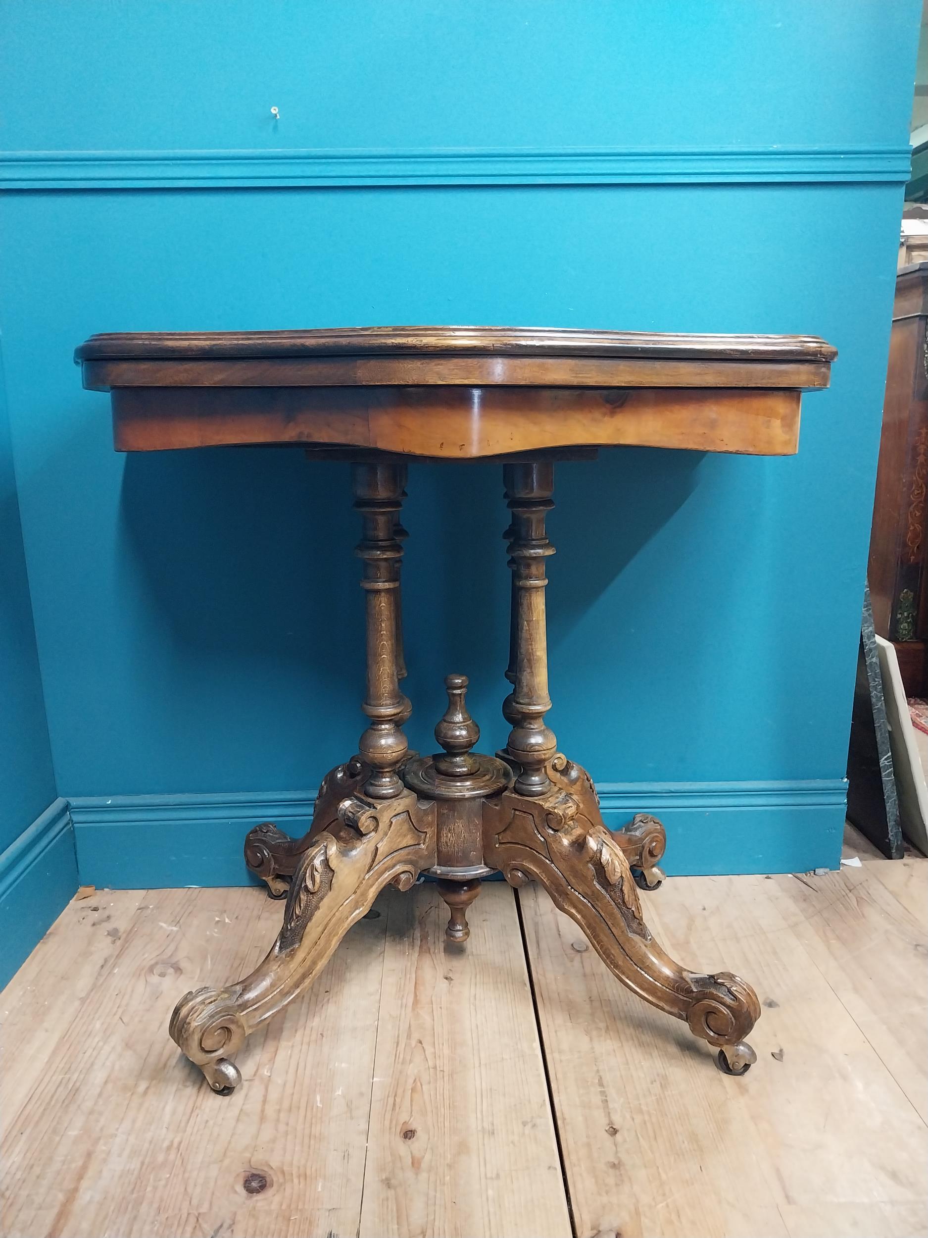 19th C. walnut turn over leaf card table raised on turned columns, four carved outwept feet and