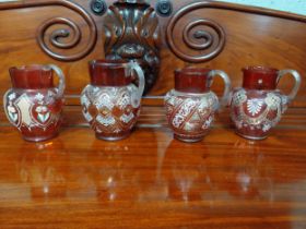 Four 19th C. ruby glass jugs. {20 cm H to 17 cm H}.