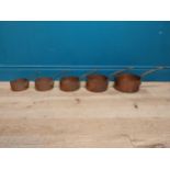 Set of five graduated copper saucepans with wrought iron handles. {20 cm H 42 cm W x 21 cm D} to {14