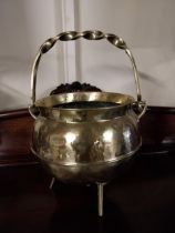 Edwardian brass coal bucket with brass handle raised on three legs {50 cm H x 36 cm Dia.}.