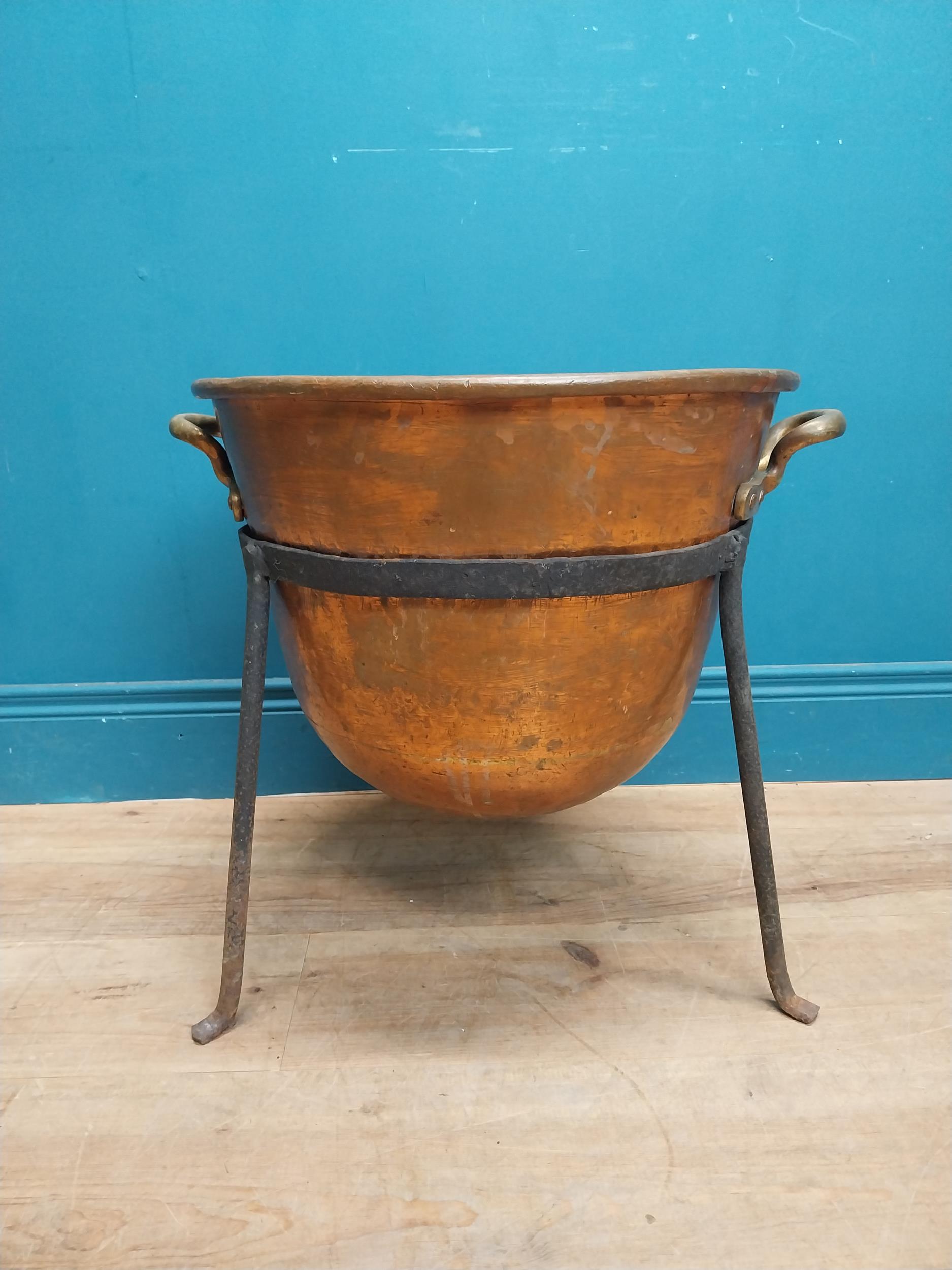 Early 20th C. copper and metal log bucket with two handles on tripod base. {}