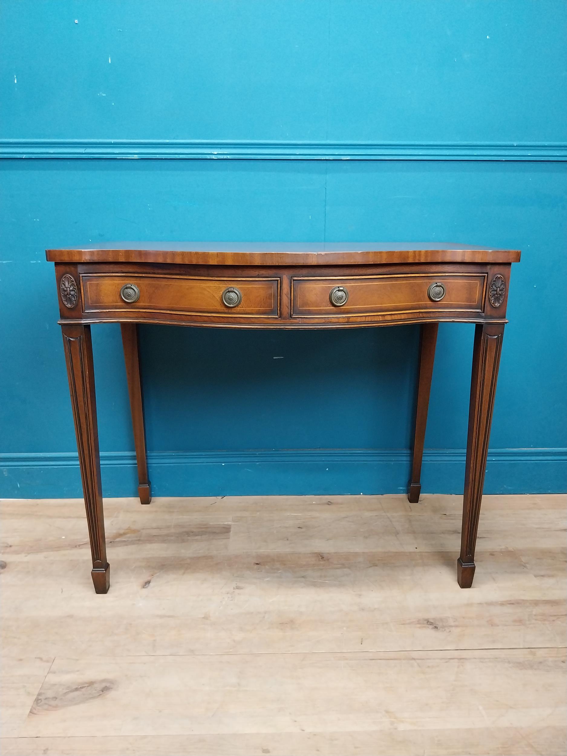 Mahogany and satinwood side table with serpentine front and two drawers in frieze raised on