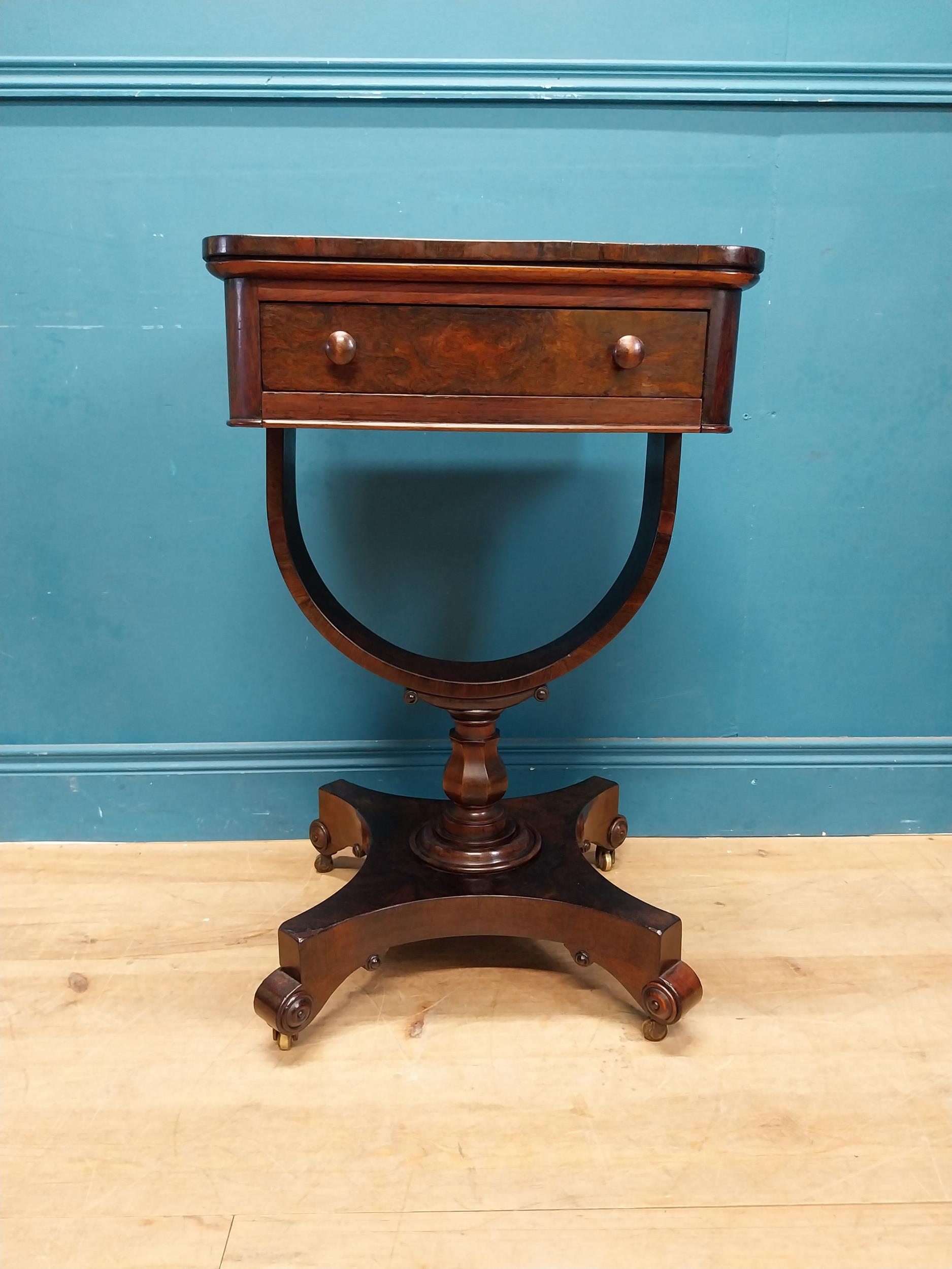 William IV rosewood lamp table with single drawer in frieze raised on bow shaped support on platform