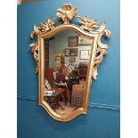 Gilt wall mirror mounted in a shield shaped frame surmounted with foliage. { 157cm H X 110cm W }.