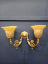 Double brass wall light with amber shade.