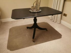 Ebonised centre table with single column raised on three legs and brass feet in the Regency