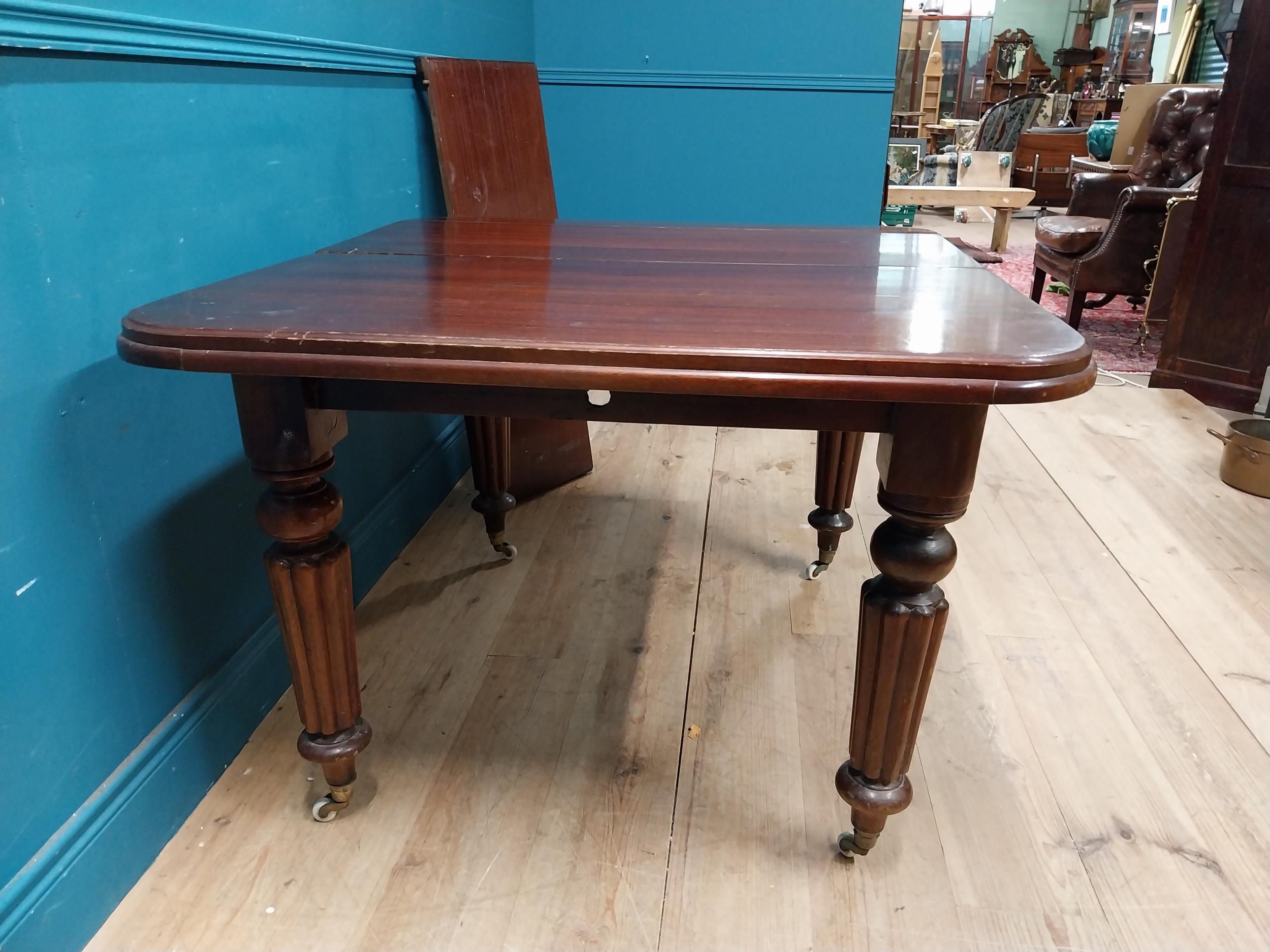 Victorian mahogany dining room table with one extra leaf raised on turned legs and brass and castors - Image 5 of 5