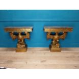 Pair of gilt cast metal marble topped console tables with outspread eagles on base in the William