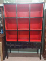 20th C. Chinese ebonised bookcase with nine open shelves over eight short drawers on square legs. {