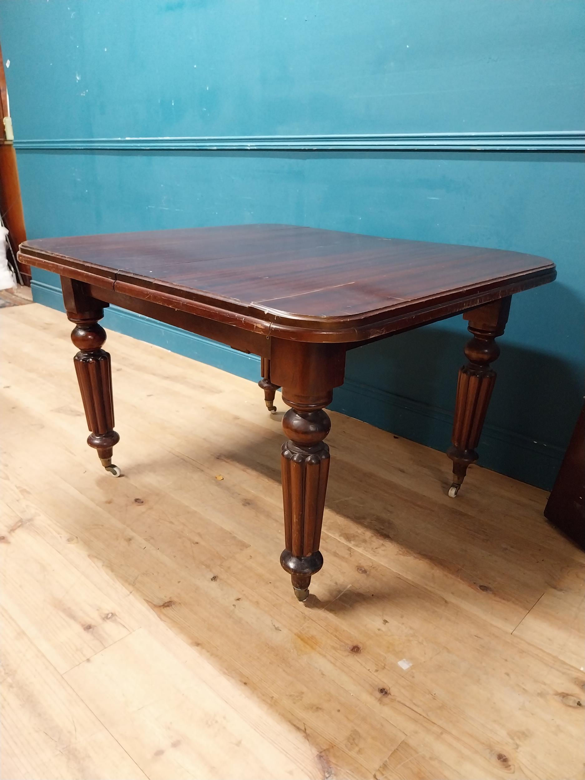 Victorian mahogany dining room table with one extra leaf raised on turned legs and brass and castors - Image 3 of 5