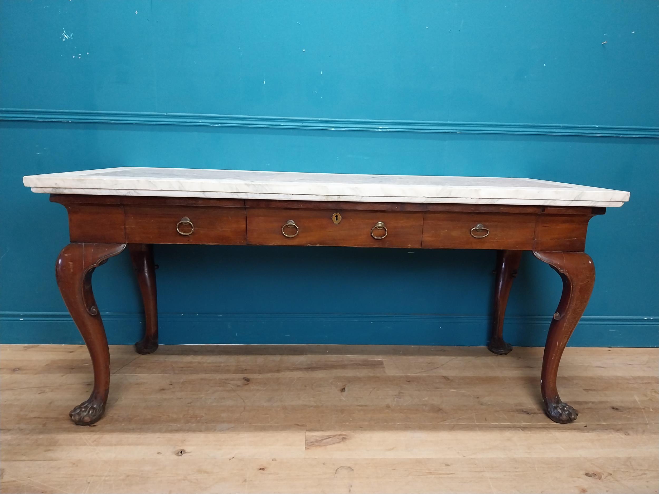 19th C. Irish mahogany side table raised on claw feet with three drawers in frieze with marble